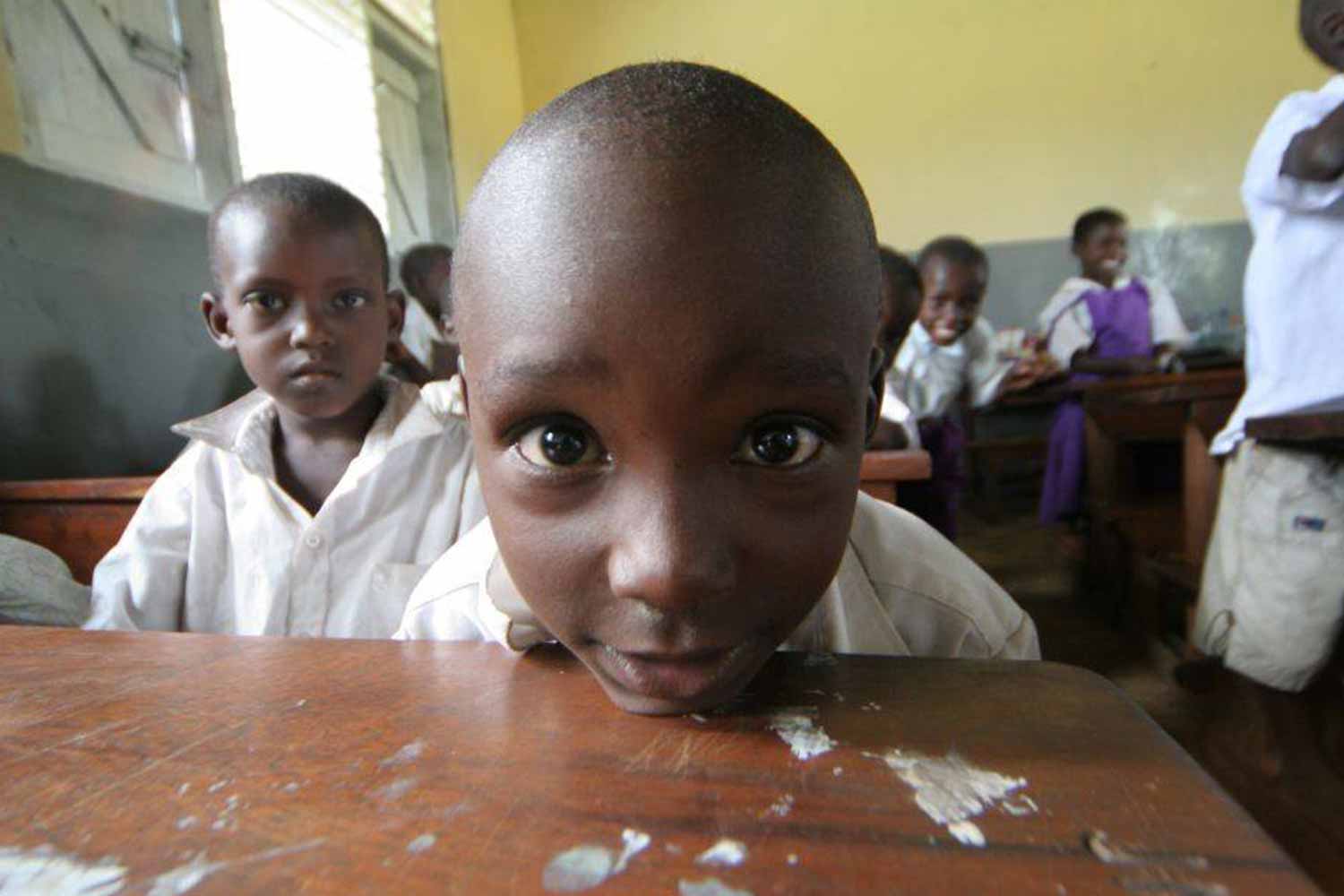 young boy with head on desk for photo