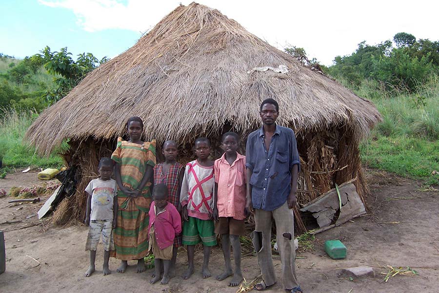 young family outside of hut smiling for photo